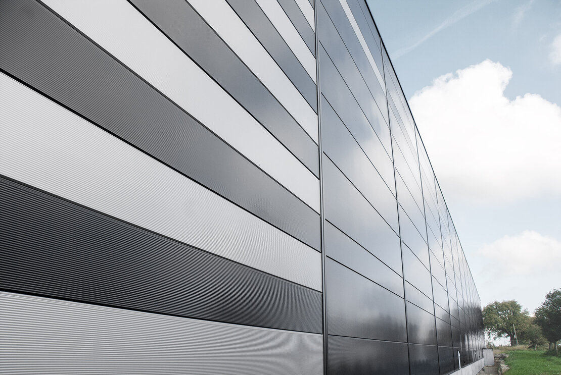 Fassade mit microprofilierter Oberfläche der Sandwichpaneele in Sonderfarbton ähnlich RAL 7021 Schwarzgrau + Farbton ähnlich RAL 9006