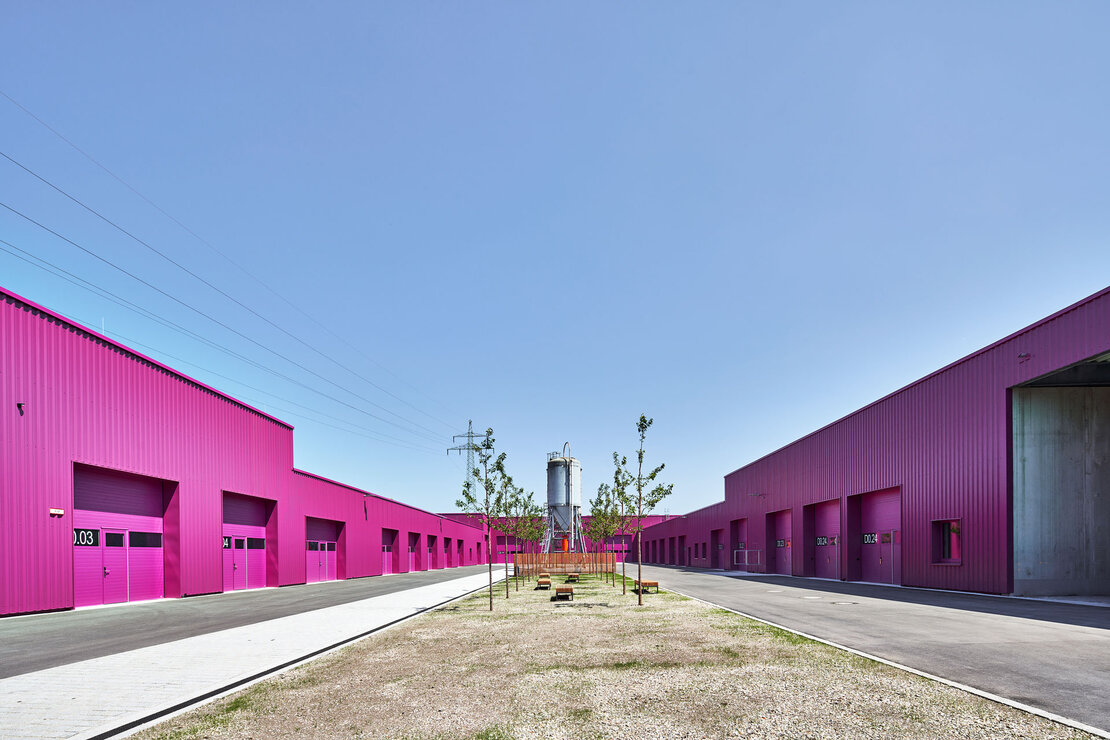 Innenhof mit gegenüberliegenden Hallenzeilen aus purpurfarbenem Stahl-Trapezprofil