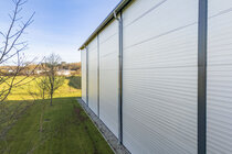 Außenansicht einer Gewerbehalle mit Sandwichpaneelen mit W-Linierung.