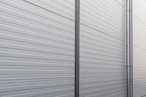 Detailansicht einer Fassade aus Sandwichpaneelen mit W-Linierung.