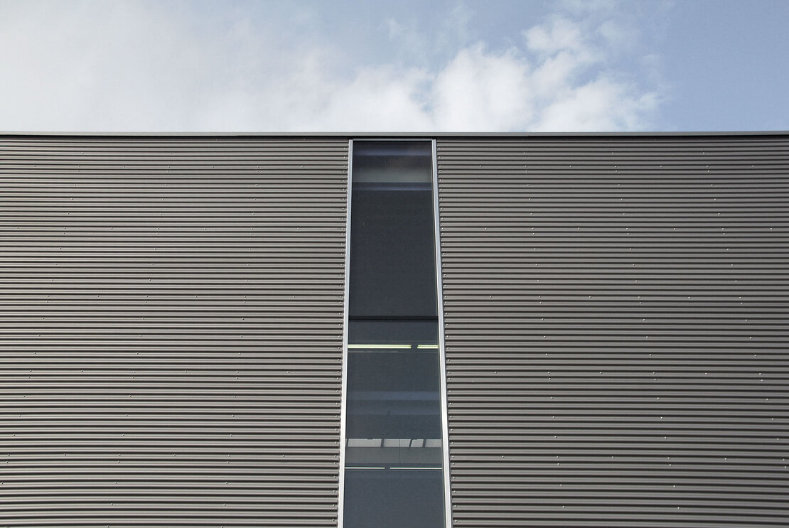 Fassade der Produktionshalle mit Wellprofilen in Sonderfarbton 800