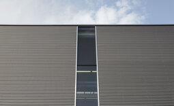 Fassade der Produktionshalle mit Wellprofilen in Sonderfarbton 800
