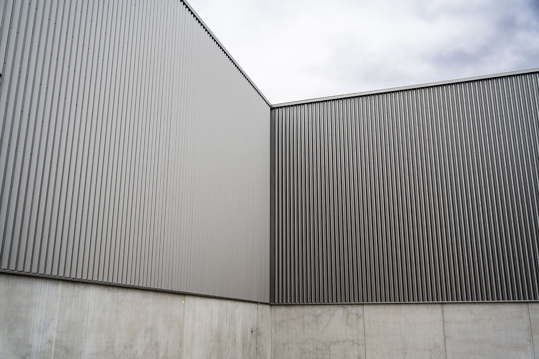 Wandfläche der Produktionshalle mit durchgängiger Profilierung und homogener Linienwirkung der Stahlfassade