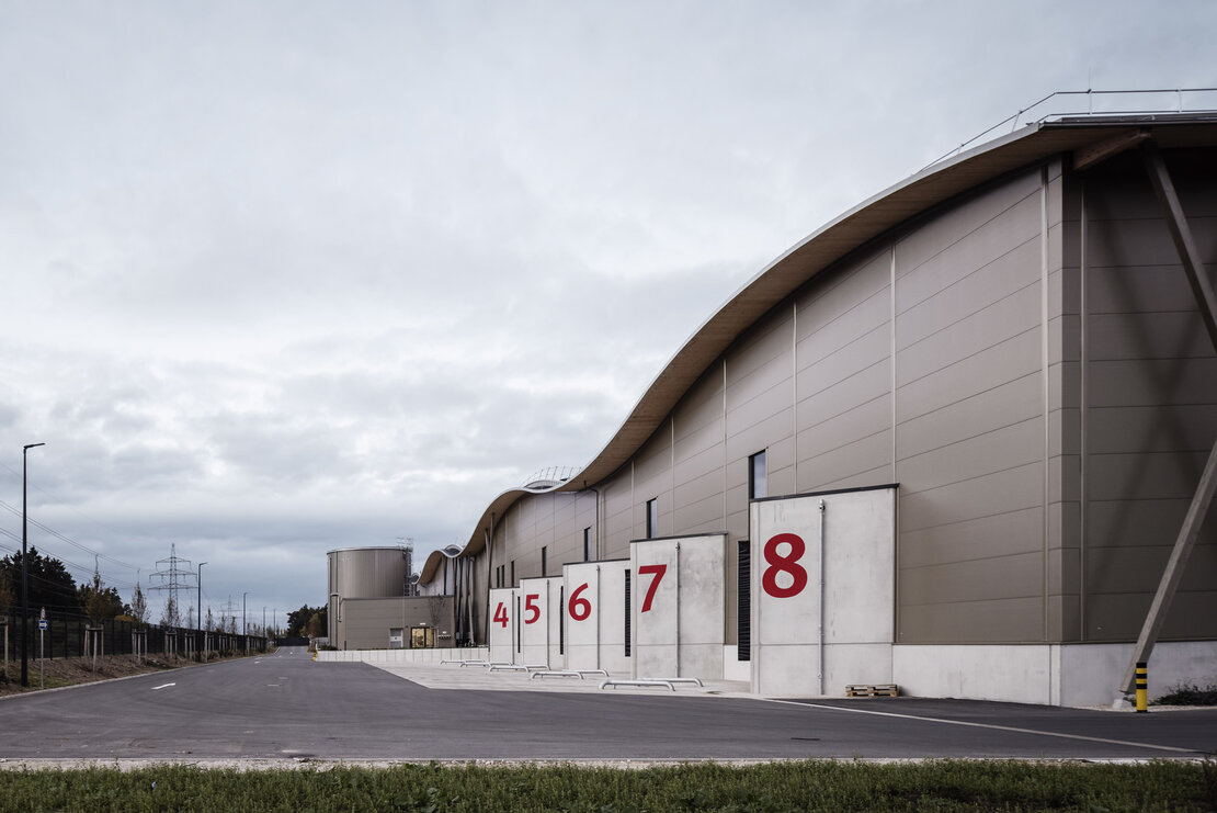 Seitenansicht Logistikzentrum Neumarkt mit Ladezone und horizontal verlegten Mineralwollpaneelen Typ FV eco und vertikalen Lisenen