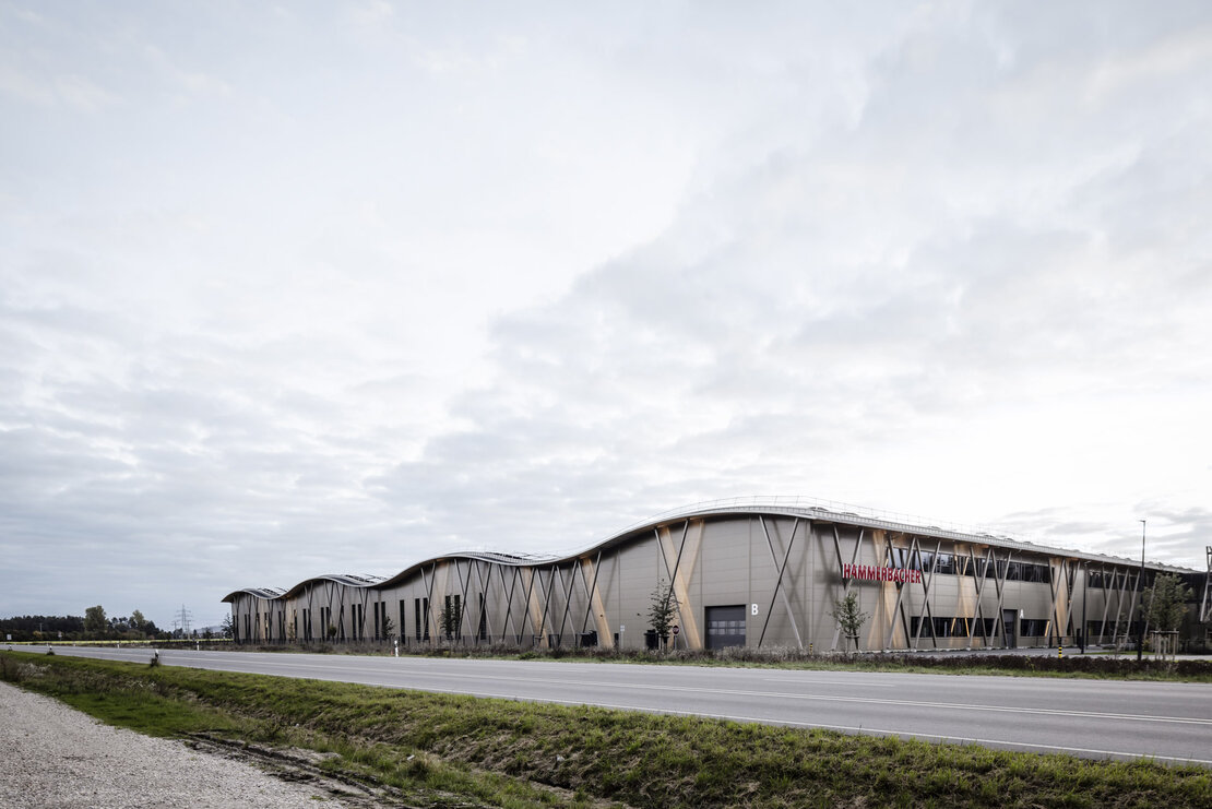 Straßenansicht Hammerbacher Logistikzentrum Neumarkt mit mikrolinierter Sandwichfassade Typ FV eco in Perlbeige und wellenförmigem Dach