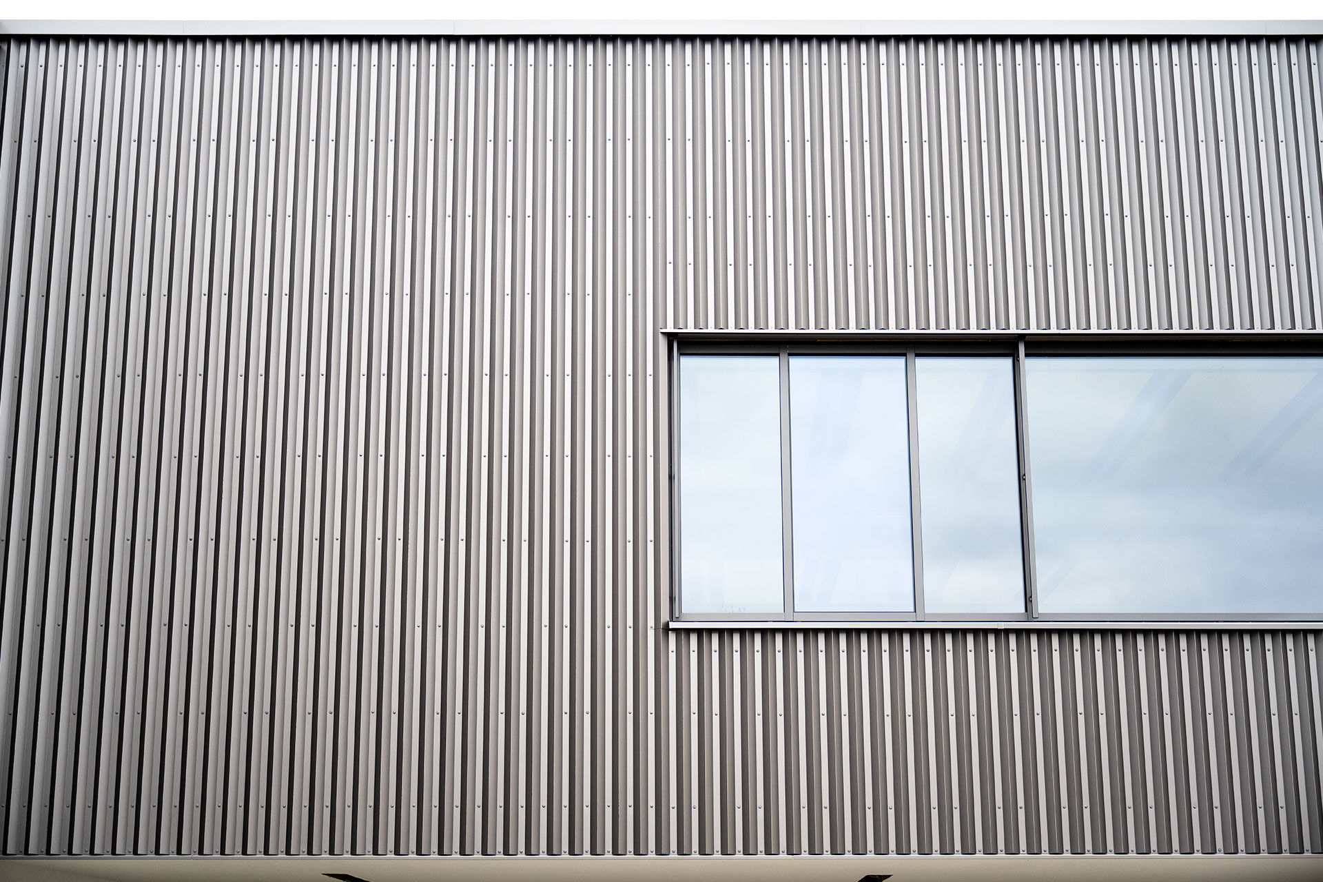 Fassadenausschnitt mit integriertem Fensterband und präziser Ausführung der Metallprofile