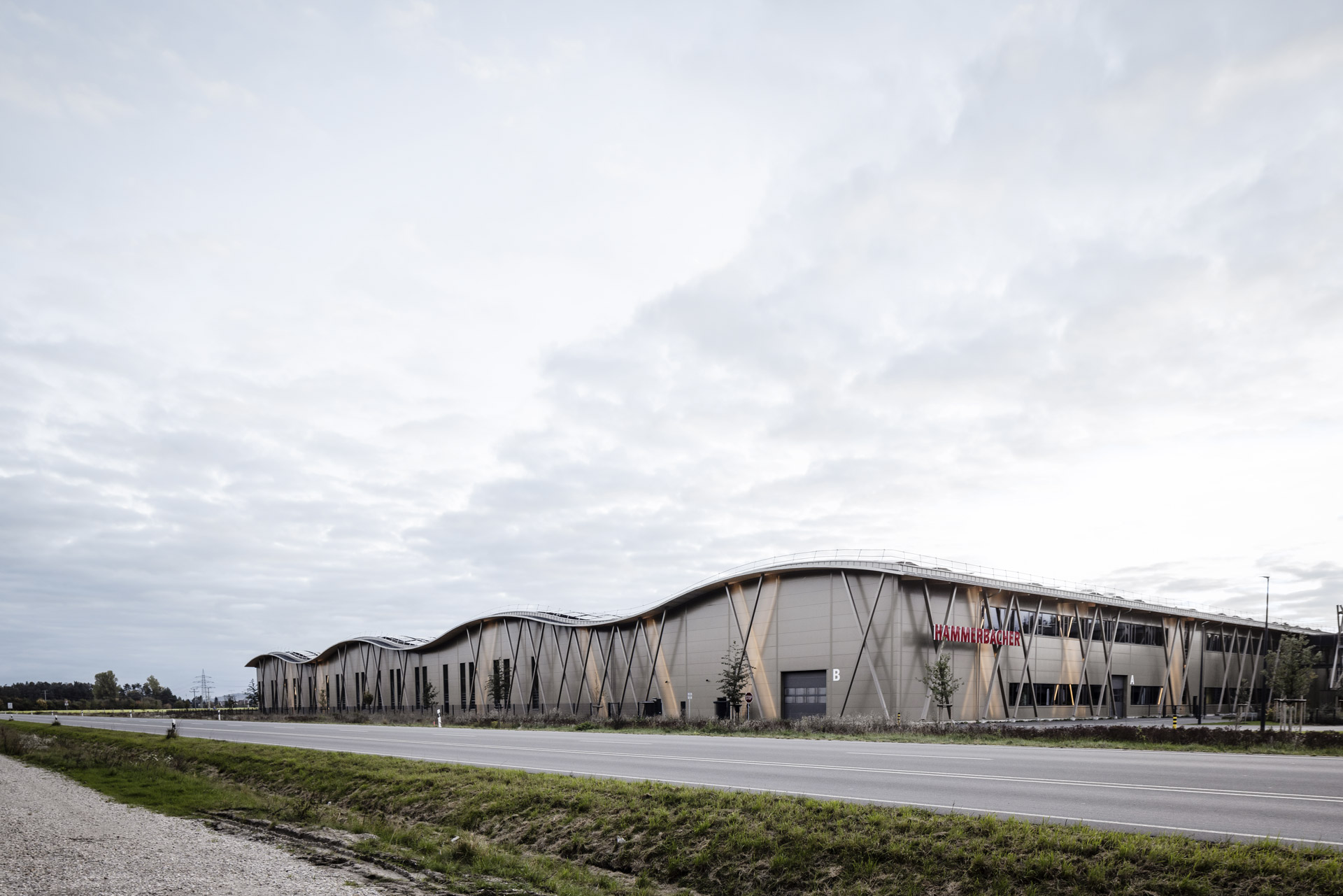 Straßenansicht Hammerbacher Logistikzentrum Neumarkt mit mikrolinierter Sandwichfassade Typ FV eco in Perlbeige und wellenförmigem Dach