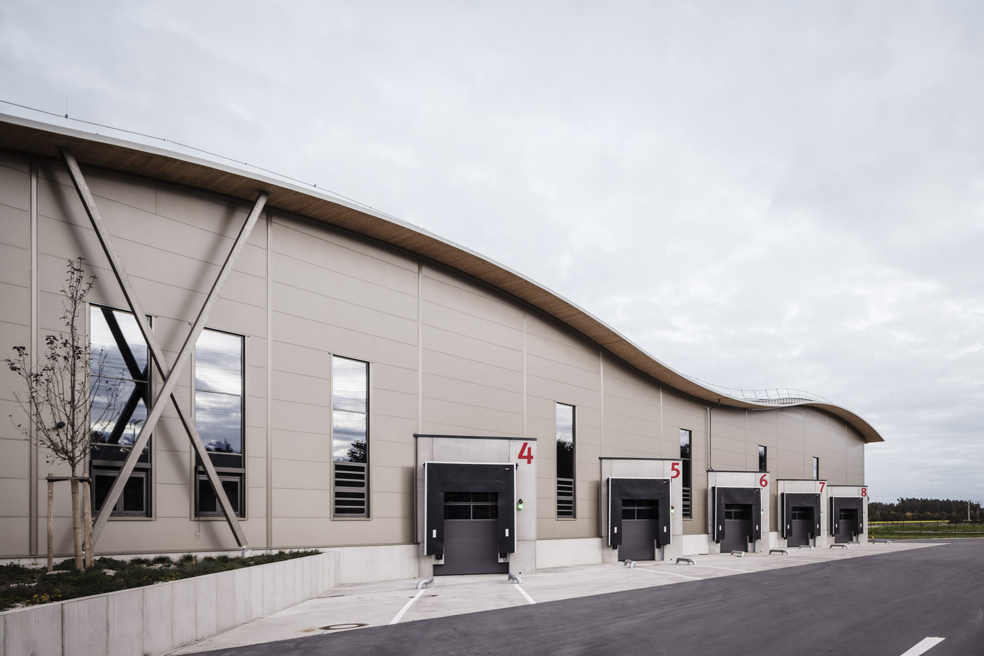 Ladezone Logistikzentrum Neumarkt mit Toren und perlbeiger Fassade mit verdeckt befestigten Roma Sandwichpaneelen